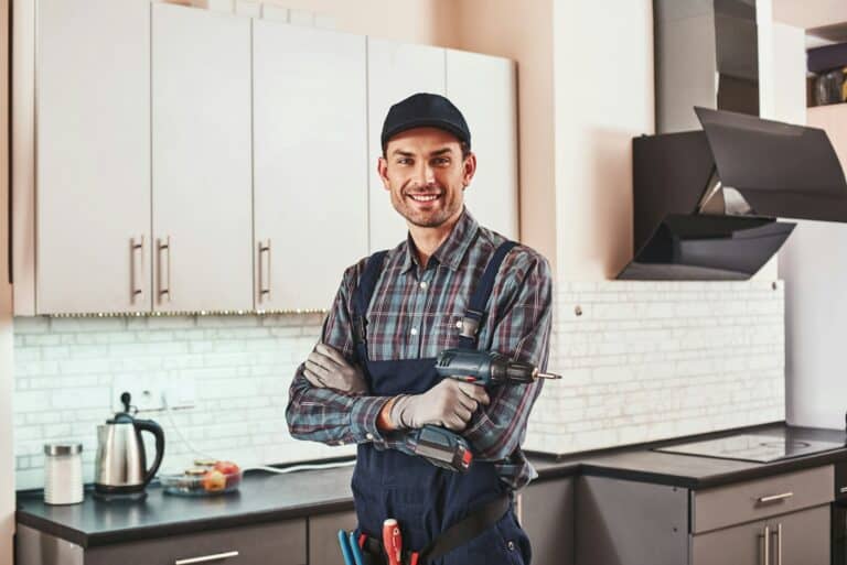 Modern handyman. Portrait of a smiling male foreman standing with perforator